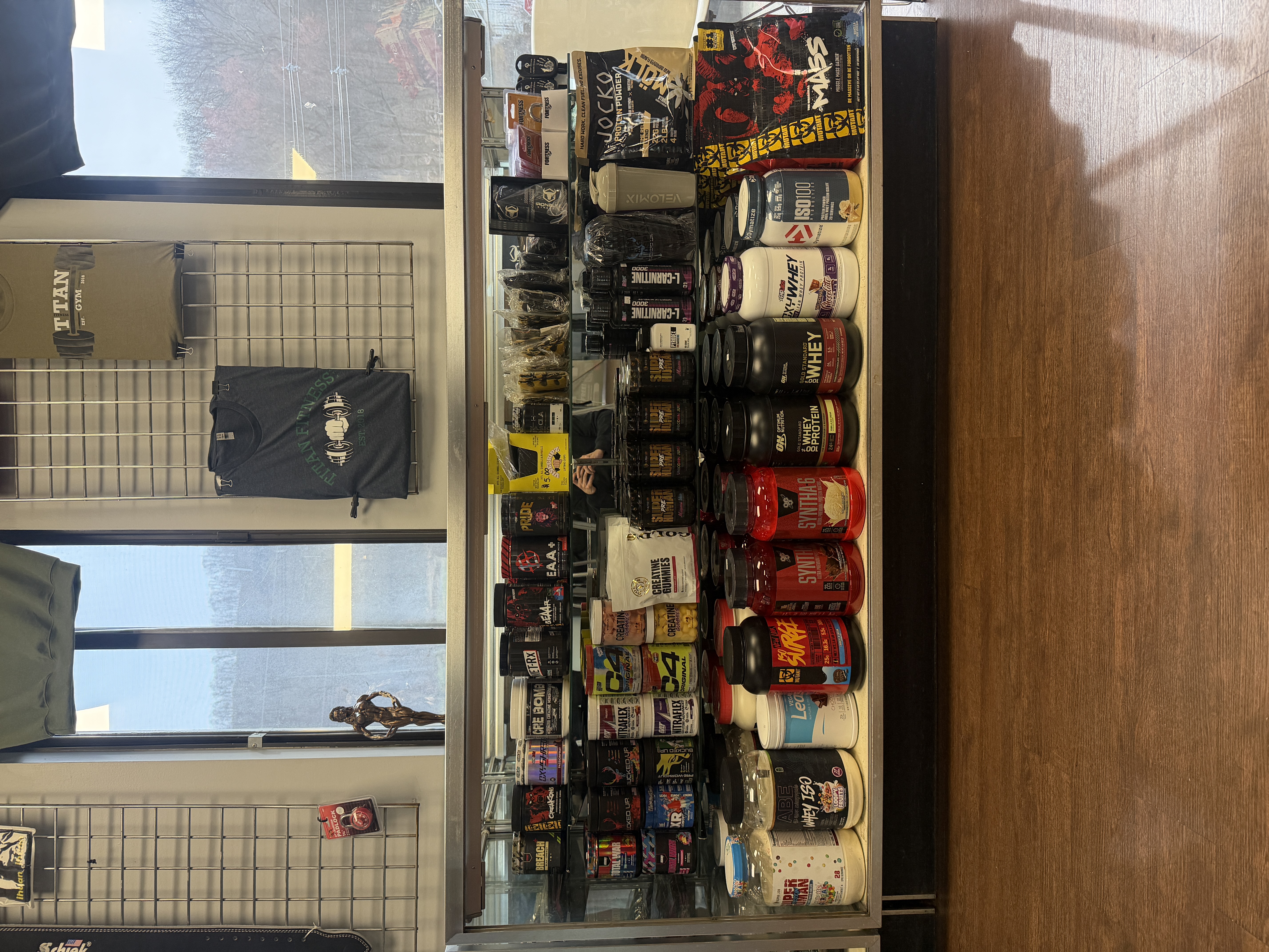 Supplement display case at Titan Fitness with protein, pre-workout, and more